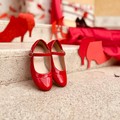 Sagome di scarpe e un drappo rosso alla scuola  "Vaccina " per la giornata contro la violenza sulle donne