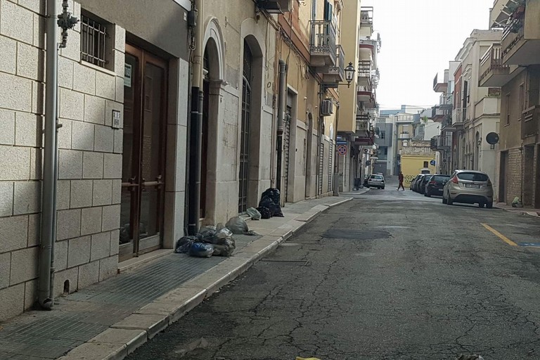vie cittadine con buste dei rifiuti