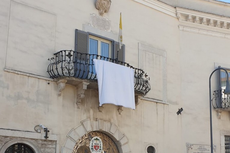 Lenzuolo bianco apposto sul balcone della Curia vescovile